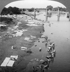 Dbobies washing clothes in the Goomti River, near Lucknow, India, 1900s.Artist: Underwood & Underwood