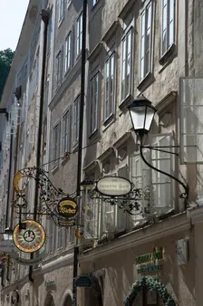 Detail view of the traditional signs along an old building on Getreidegasse, Salzburg, Austria, 2022 Creator: Ethel Davies