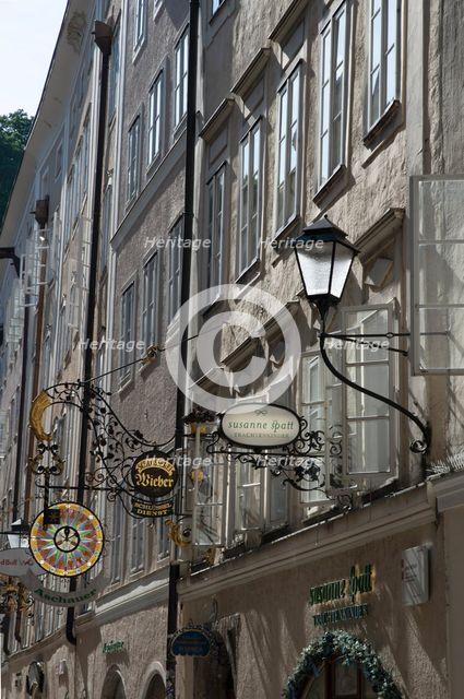 Detail view of the traditional signs along an old building on Getreidegasse, Salzburg, Austria, 2022 Creator: Ethel Davies.