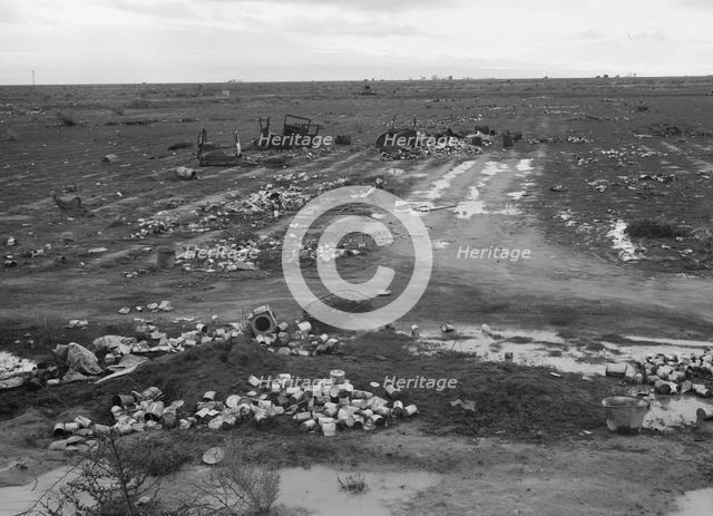 Debris left out on the flats where squatters' camp stood during work season, Kern County, 1939. Creator: Dorothea Lange.