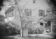 DeLamar, Alice, Miss, and unidentified woman by house, between 1927 and 1942. Creator: Arnold Genthe