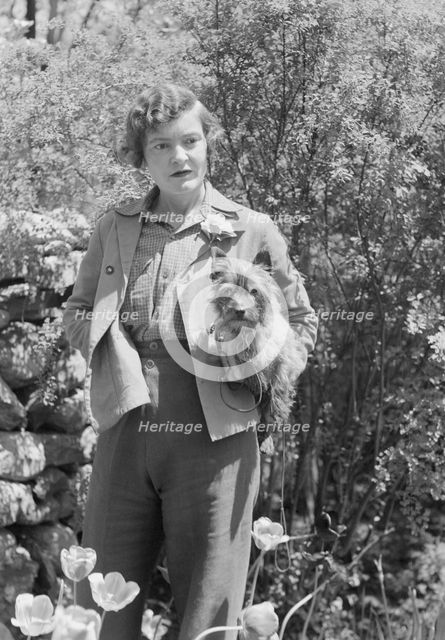 DeLamar, Alice, Miss, with dog, standing outdoors, between 1927 and 1942. Creator: Arnold Genthe.