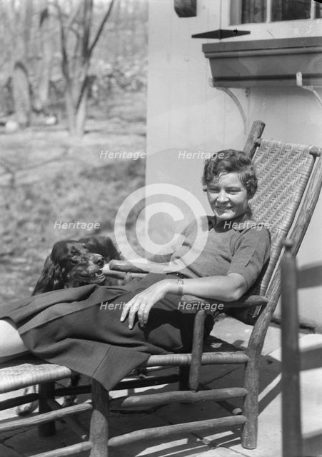 DeLamar, Alice, Miss, with dog, seated outdoors, between 1927 and 1942. Creator: Arnold Genthe.
