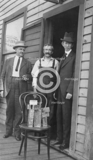 Delegate Wickersham, the assayer and Frank G. Carpenter in front of..., between c1900 and 1916. Creator: Unknown.