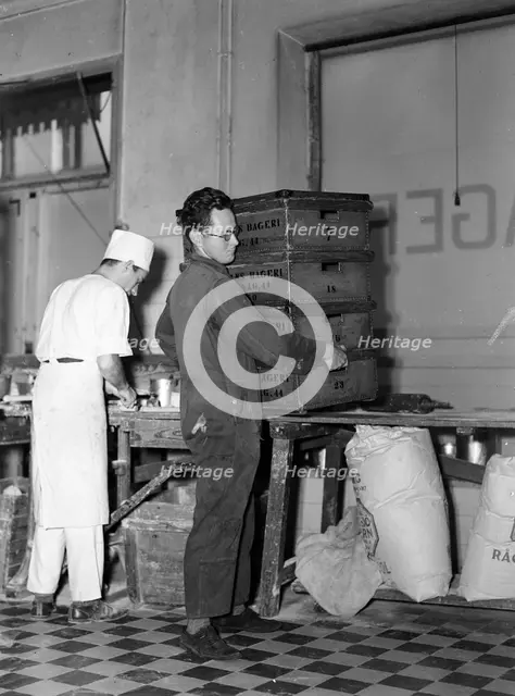 Delivery boy picking up bread  boxes at the Lisa Öhman Bakery, Stockholm, Sweden, 10th October 1942. Creator: Karl Sandels.