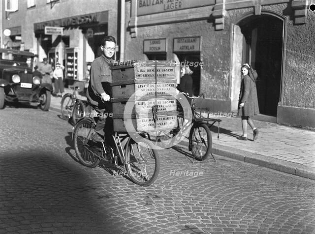 Delivery boy with bread boxes from the Lisa Öhman Bakery, Stockholm, Sweden, 10th October 1942. Artist: Karl Sandels
