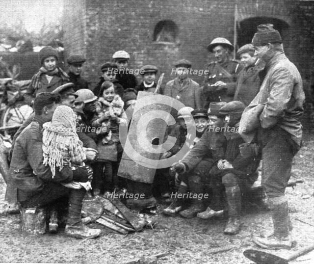 'Delivres ! ; La population enfantine d'un village libere se presse autour d'un brasero improvise pa Creator: Unknown.