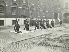 Demonstrating how to pick up an unconscious person, London Fire Brigade Headquarters, London, 1910