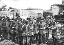 Derriere L'ennemi refoule; Nos territoriaux distribuent du pain a des prisonniers...1915 (1924). Creator: Unknown