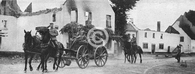 'Des equipages allemands traversent, pres de Vise, le village de Mouland incendie', 1914. Creator: Vereenigde Fotobureaux Amsterdam.