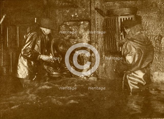 'Divers Plugging A Leak During Salvage Operations Waist-Deep In Water On the Lower Decks Of The Germ Creator: Unknown.