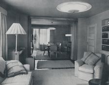 Dining and living room, divided only by heavy curtains in an attractive modern weave 1942