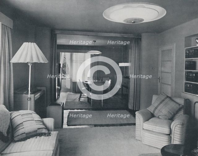 'Dining and living room, divided only by heavy curtains in an attractive modern weave', 1942. Artist: Unknown.