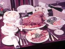 Dining table with roast dinner, c1955. Creator: Arthur Charles Kirby Ware