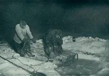 Dr. Atkinson and Clissold Hauling Up The Fish-Trap 28 May 1911, (1913). Artist: Herbert Ponting