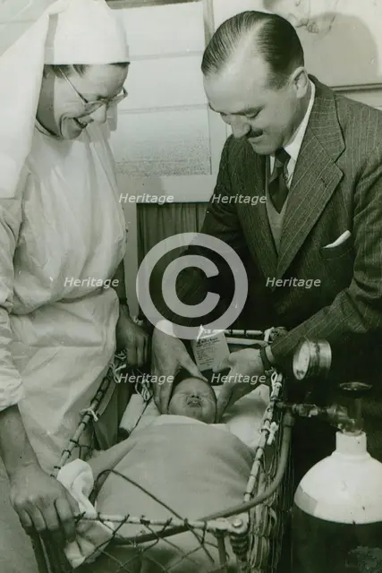 Dr Geoffrey Mutton and Matron Joan Gardner attend to a baby at St Monan's Hospital, c1950. Creator: Unknown.