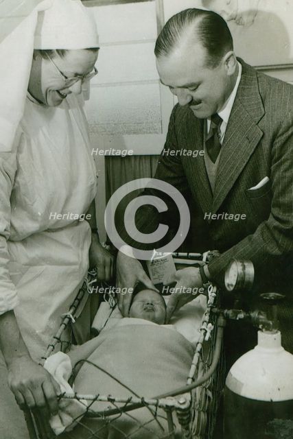Dr Geoffrey Mutton and Matron Joan Gardner attend to a baby at St Monan's Hospital, c1950. Creator: Unknown.