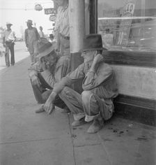 Drought farmers line the shady side of the main street of the town, Sallisaw, Oklahoma, 1936. Creator: Dorothea Lange