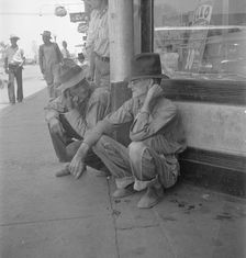 Drought farmers line the shady side of the main street of the town, Sallisaw, Oklahoma, 1936. Creator: Dorothea Lange