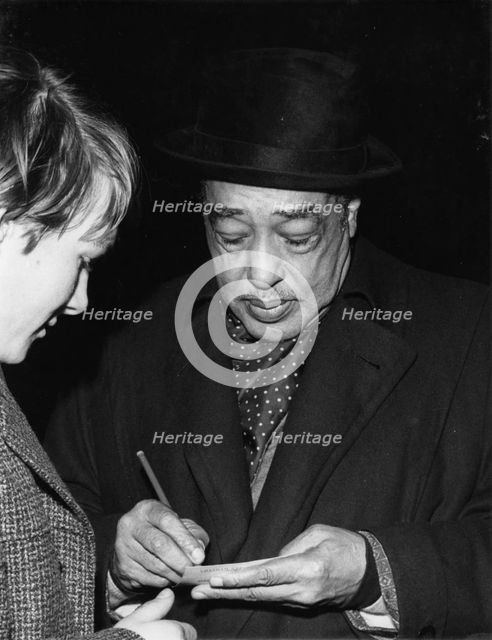 Duke Ellington signing his autograph, c1962. Creator: Brian Foskett.