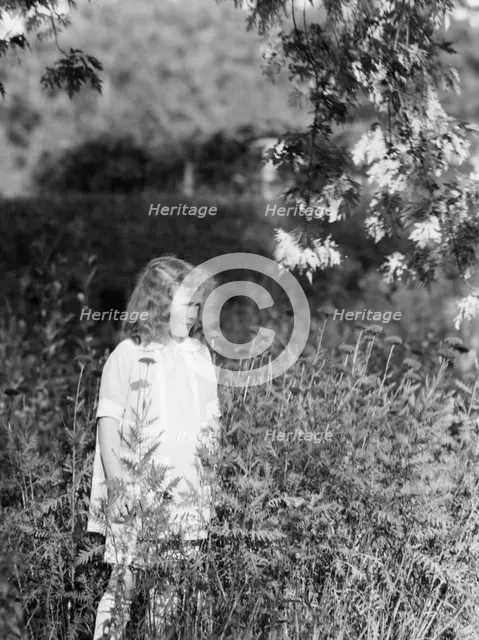 Dunning, Mr., daughter of, standing in a garden, 1925 July 9. Creator: Arnold Genthe.