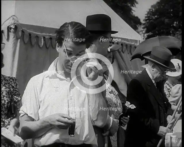 Emlyn Williams, Actor, Timing Punters by the 'Fishing for Fizz' Stall at  the Theatrical..., 1939. Creator: British Pathe Ltd.