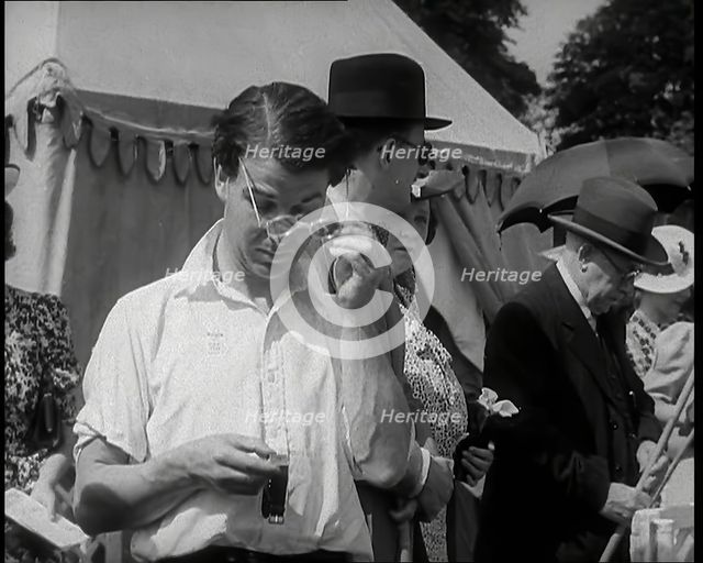 Emlyn Williams, Actor, Timing Punters by the 'Fishing for Fizz' Stall at  the Theatrical..., 1939. Creator: British Pathe Ltd.