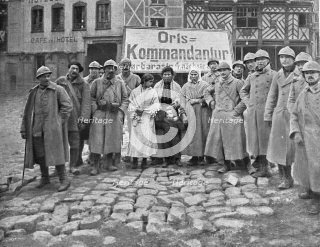 'En territoire libere; Dans Roye delivre le 17 mars: soldats et habitants devant l'ecriteau decroche Creator: Unknown.