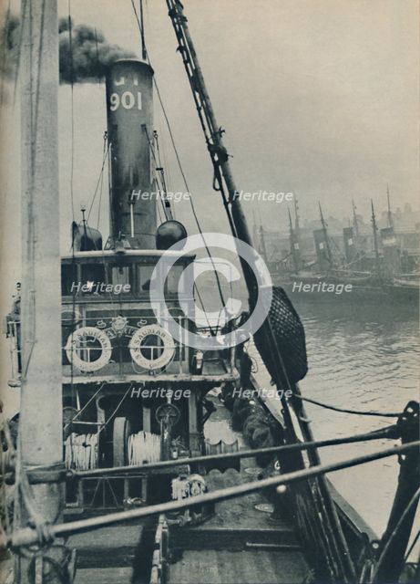 'Entering Grimsby Docks at the end of a North Sea voyage is the fishing vessel Saurian', 1937. Artist: Unknown.