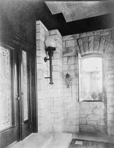 Entrance with etched glass door at left, sconce, and open window..., Greenwich, Connecticut, 1908. Creator: Frances Benjamin Johnston