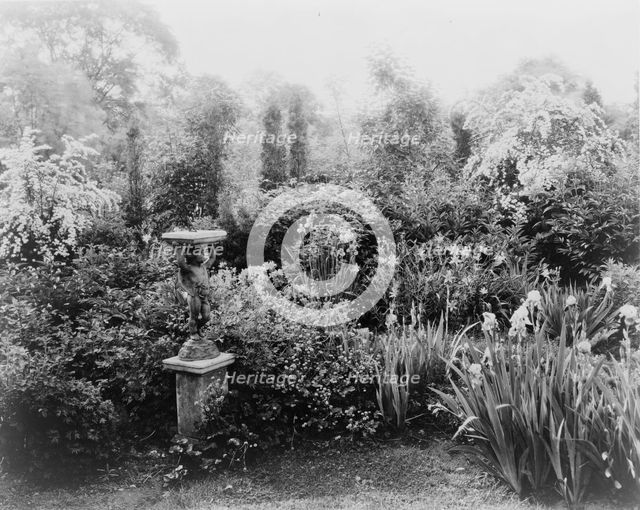 English lead figurine holding sundial, Graham Nichols garden, Greenwich, Connecticut, c1908 - 1927. Creator: Frances Benjamin Johnston.