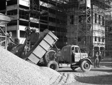 Early 1950s Bedford M Tipper delivering aggregates to a building site, South Yorkshire, July 1954. Creator: Michael Walters