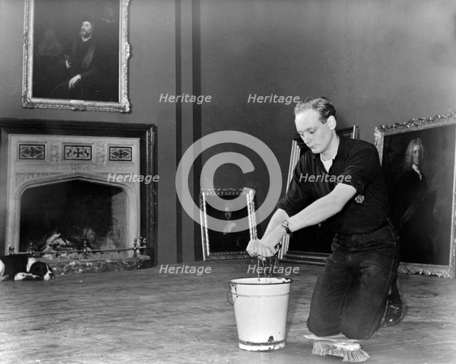 Edward, Lord Montagu of Beaulieu scrubbing floors in Palace House 1952. Creator: Unknown.
