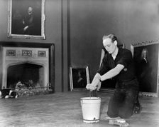 Edward, Lord Montagu of Beaulieu scrubbing floors in Palace House 1952. Creator: Unknown