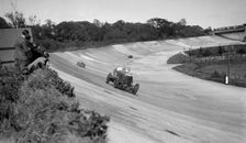 Eddie Hall's Bentley leading a Bugatti on the banking at Brooklands. Artist: Bill Brunell