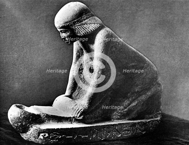 Egyptian tomb figure of a woman grinding corn using a saddle quern, c2500 BC. Artist: Unknown