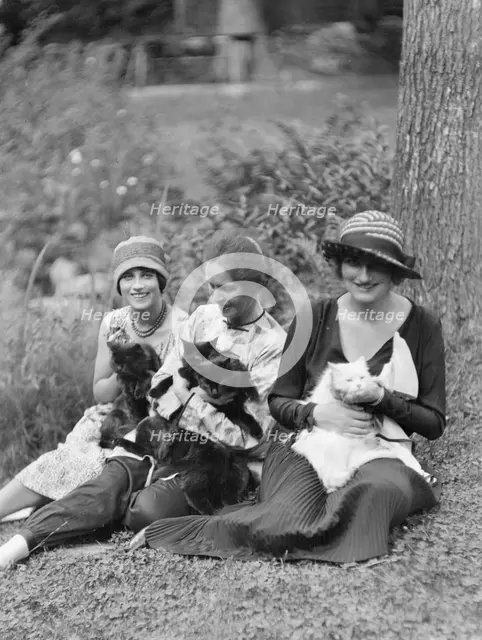 Egger, Gabrielle, Miss, and friends, with cats, seated outdoors, between 1926 and 1930. Creator: Arnold Genthe.