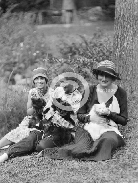 Egger, Gabrielle, Miss, and friends, with cats, seated outdoors, between 1926 and 1930. Creator: Arnold Genthe.