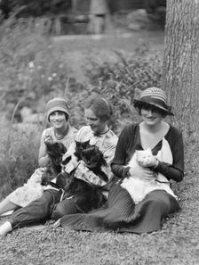 Egger, Gabrielle, Miss, and friends, with cats, seated outdoors, between 1926 and 1930. Creator: Arnold Genthe