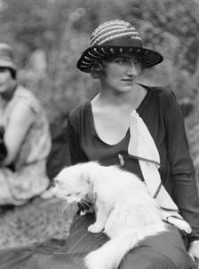 Egger, Gabrielle, Miss, with cat, seated outdoors, between 1926 and 1930. Creator: Arnold Genthe