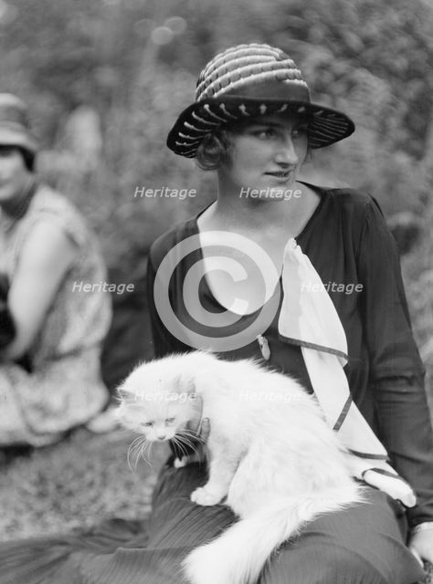 Egger, Gabrielle, Miss, with cat, seated outdoors, between 1926 and 1930. Creator: Arnold Genthe.