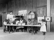 Eight African American children, in kindergarten, learning washing and ironing..., 1899 or 1900. Creator: Frances Benjamin Johnston