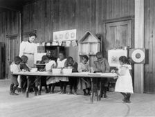 Eight African American children, in kindergarten, learning washing and ironing..., 1899 or 1900. Creator: Frances Benjamin Johnston