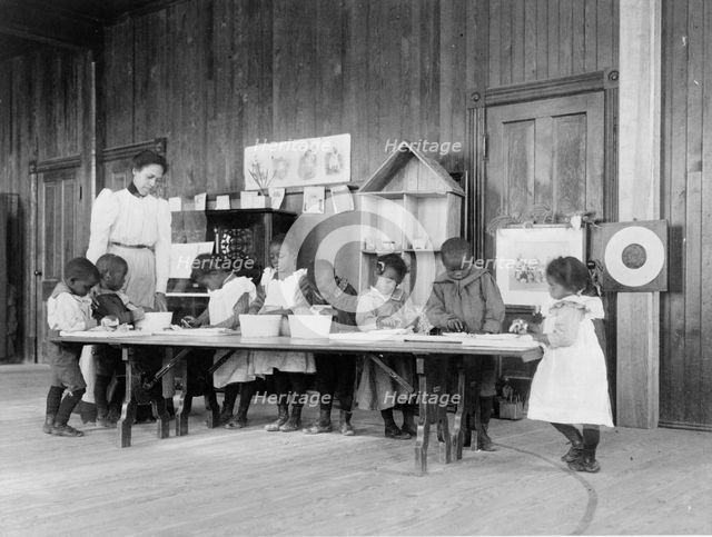Eight African American children, in kindergarten, learning washing and ironing..., 1899 or 1900. Creator: Frances Benjamin Johnston.