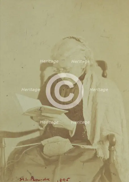 Elderly woman seated and reading a book with knitting in her lap, 1895. Creator: Horace L Bundy.
