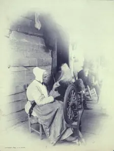 Elderly woman sitting on porch spinning, c1894. Creator: Charles Richards Dodge