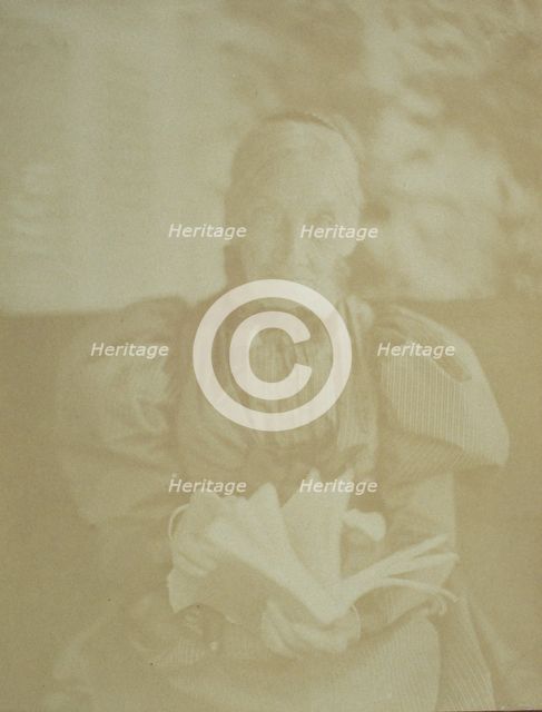 Elderly woman sitting in a chair holding a book, half-length portrait, facing front, c1890. Creator: Horace L Bundy.