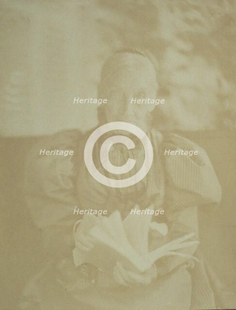 Elderly woman sitting in a chair holding a book, half-length portrait, facing front, c1890. Creator: Horace L Bundy.