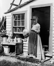 Elderly woman, standing at doorway, on Mackinac Island, Michigan, 1903. Creator: Frances Benjamin Johnston