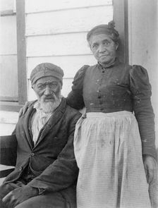 Elderly African American couple posed outside of building, near Hampton Institute..., 1899 or 1900. Creator: Frances Benjamin Johnston